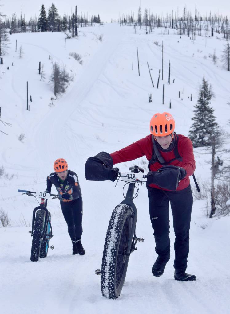 Tyle Owens pushes up a hill ahead of Chaz DiMarzio during Fat Freddies Bike Race and Ramble on Saturday, Feb. 9, 2019, in the Caribou Hills near Freddies Roadhouse. (Photo by Jeff Helminiak/Peninsula Clarion)