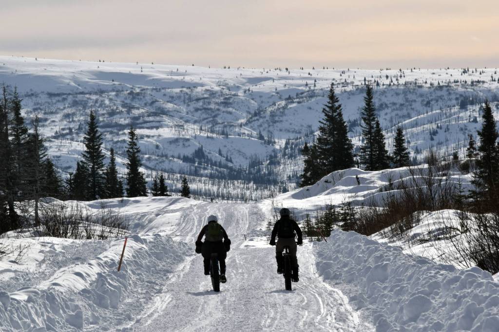 Martha Story and David Story cruise down a hill in the Fat Freddies Bike Race and Ramble on Saturday, Feb. 9, 2019, in the Caribou Hills near Freddies Roadhouse. (Photo by Jeff Helminiak/Peninsula Clarion)