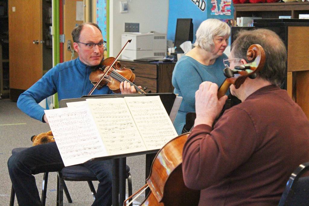 Daniel Perry (violin), Susan Wingrove-Reed (piano) and Mannfried Funk (cello) perform chamber music Friday, Feb. 15, 2019 at Paul Banks Elementary School in Homer, Alaska. The group performed a concert later that weekend at Bunnell Street Arts Center asa fundraiser for a new group, Orchestral Programs Unified Steering, formed to help support local ensemble groups for youth. (Photo by Megan Pacer/Homer News)