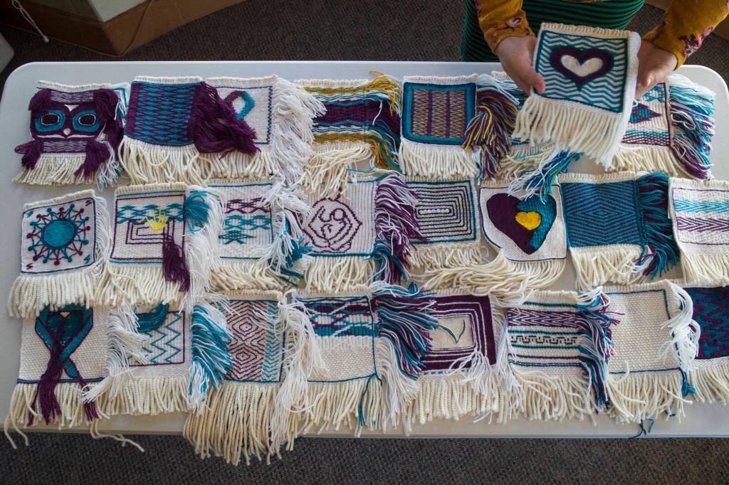 Weaver Lily Hope lays out woven squares for a new project called the Giving Strength Robe on Friday, Feb. 15, 2019. Hope is organizing dozens of Chilkat and Ravenstail weavers from all over North America to weave 5-inch-by-5-inch squares that will be combined to make one traditional indigenous robe. Once completed, the robe will be given to Aiding Women in Abuse and Rape Emergencies (AWARE). (Michael Penn | Juneau Empire)