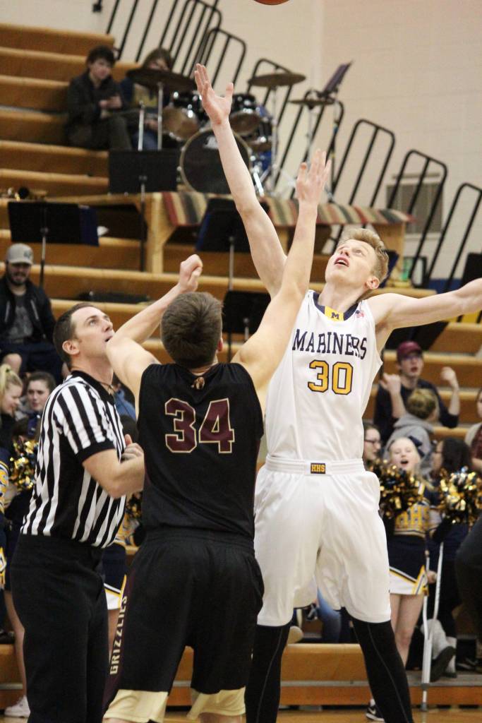 Homers Japheth McGhee and Grace Christian Schools Andrew Beck jump for the tipoff at the start of a Friday, Feb. 22, 2019 game in Homer, Alaska. McGhee was celebrated along with three other senior Mariners players at the Senior Night game. (Photo by Megan Pacer/Homer News)