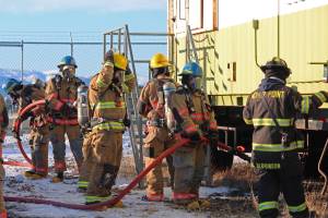 Firefighters from multiple agencies prepare to enter a structure with a fire burning inside it as part of a live fire exercise Saturday, Feb. 23, 2019 at the Homer Volunteer Fire Departments fire training facility on Freight Dock Road in Homer, Alaska. Student volunteers rom Anchor Point Emergency Services, Homer Volunteer Fire Department, Ninilchik Emergency Services, and Central Emergency Services attended the drill as part of a joint Firefighter I class they are attending hosted by Anchor Point Fire and HVFD. (Photo by Megan Pacer/Homer News)