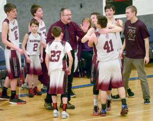Nikolaevsk coach Steve Klaich celebrates with his team after winning his first Peninsula Conference title in his 30th season at the helm Friday at Cook Inlet Academy in Soldotna. (Photo by Jeff Helminiak/Peninsula Clarion)