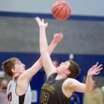 Nikolaevsks Kosta Nikitenko and Ninilchiks Jake Clark battle for the opening tip Friday in the Peninsula Conference championship game at Cook Inlet Academy in Soldotna. (Photo by Jeff Helminiak/Peninsula Clarion)