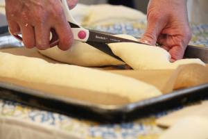 Sharon Roufa of Two Sisters Bakery cuts dough into the shape she wants during a cooking demo on how to bake with sourdough at the Alaska Food Festival on Saturday, March 9, 2019 at Lands End Resort in Homer, Alaska. (Photo by Megan Pacer/Homer News)