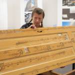 In this undated photo, Anna Pidgorna stands by her piece, Through Closed Doors. The arrangement of music on the door is designed so that musicians performing the piece must physically move around the door to act out dramatic dimensions of the piece. (Photo provided)