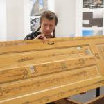 In this undated photo, Anna Pigdorna stands by her piece, Through Closed Doors. The arrangement of music on the door is designed so that musicians performing the piece must physically move around the door to act out dramatic dimensions of the piece. (Photo provided)