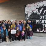 Homer-area residents pose in front of the Still Fighting for Alaska banner Homer artivist Mavis Muller made after the March 24, 1989, grounding of the Exxon Valdez, during a gathering on Sunday, March 24, 2019 on the Homer Spit in Homer, Alaska. A tear in the tankers hull allowed millions of gallons of Alaska crude to spill into Prince William Sound, fouling more than a thousand miles of Alaskas coastline. (Photo by McKibben Jackinsky)