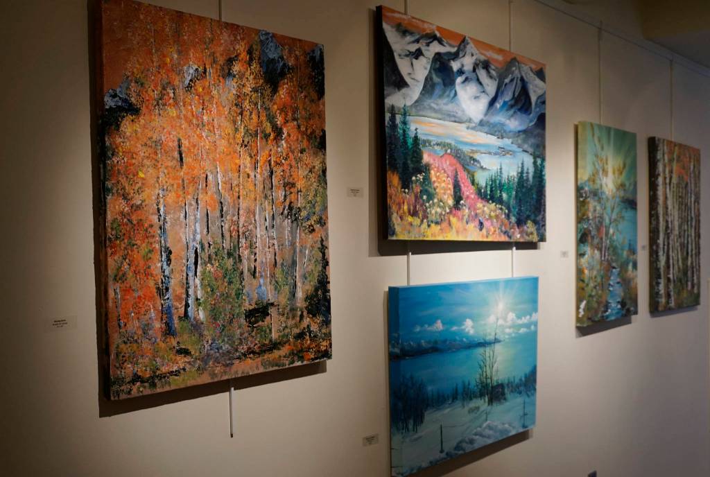 Some of John Fenskes paintings at the First Friday, April 5, 2019, opening for his retrospective showing at Kachemak Bay Campus in Homer, Alaska. (Photo by Michael Armstrong/Homer News)