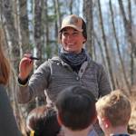 Anna Meredith explains the process of tapping birch trees for sap during a Friday, April 12, 2019 Paul Banks Elementary School field trip to the grove where Bridge Creek Birch Syrup operates on East End Road in Homer, Alaska. (Photo by Megan Pacer/Homer News)