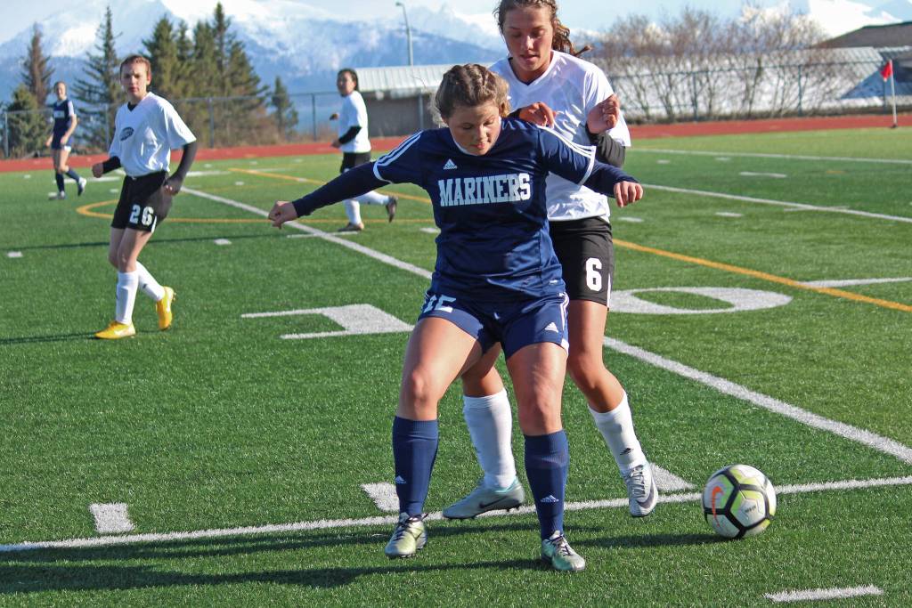 Homers Rylee Doughty gets in front of Nikiskis Emma Wik while battling for the ball during a Tuesday, April 23, 2019 game at Homer High School in Homer, Alaska. (Photo by Megan Pacer/Homer News)
