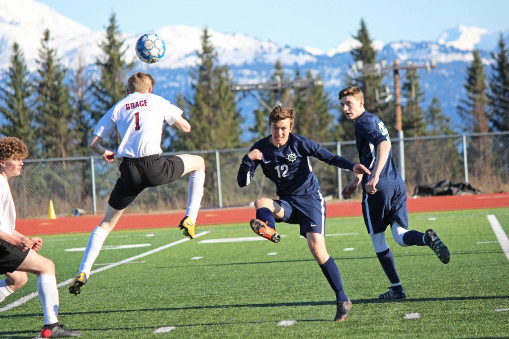 In Homer High School Mariners varsity soccer game against Grace Christian on Friday, April 26, 2019, at the high school in Homer, Alaska, Daniel Reutov, 12, battles for control of the ball, with teammate Ethan Pitzman, 15, ready to assist. (Photo by McKibben Jackinsky)