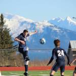 Homer Mariner Ethan Pitzman, 15, keeps the ball in play during Fridays game against Grace Christian, Friday, April 26, 2019, at the high school in Homer, Alaska while teammates Austin Shafford, 24, and Henry Russell, 33, keep the Grace Christian team at a distance. (Photo by McKibben Jackinsky)