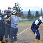 Homer High School Mariners softball batter Grace Godfrey gets a hug from her teammates after two other players scored on her hit on Tuesday, April 30, 2019, against Soldotna High School at Jack Gist Park in Homer, Alaska. (Photo by Michael Armstrong/Homer News)