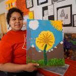 Flex School student Makayla Prescott holds up a collage she showed at Flex First Friday, an exhibit of art done by Flex students, teachers and staff over the past year. The show included pottery created during an Artist in the School residency by Jeff Szarzi. (Photo by Michael Armstrong/Homer News)