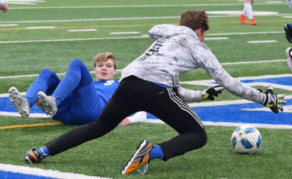 Soldotnas Rory Nelson watches as SoHi goalkeeper Colton Sorhus (forwar) falls on the ball Saturday against Homer in a Peninsula Conference game in Soldotna. (Photo by Joey Klecka/Peninsula Clarion)