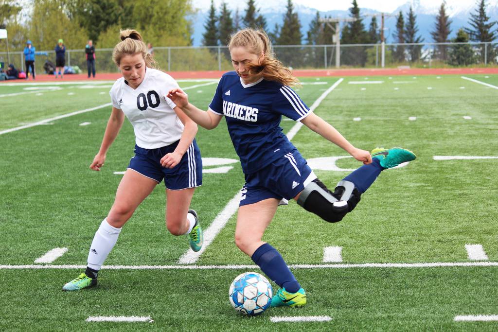 Homers Brenna McCarron (right) prepares to send the ball up the field under pressure from Soldotnas Ryann Cannava during the girls championship game of the Peninsula Conference Soccer Tournament on Saturday, May 18, 2019 at Homer High School in Homer, Alaska. (Photo by Megan Pacer/Homer News)