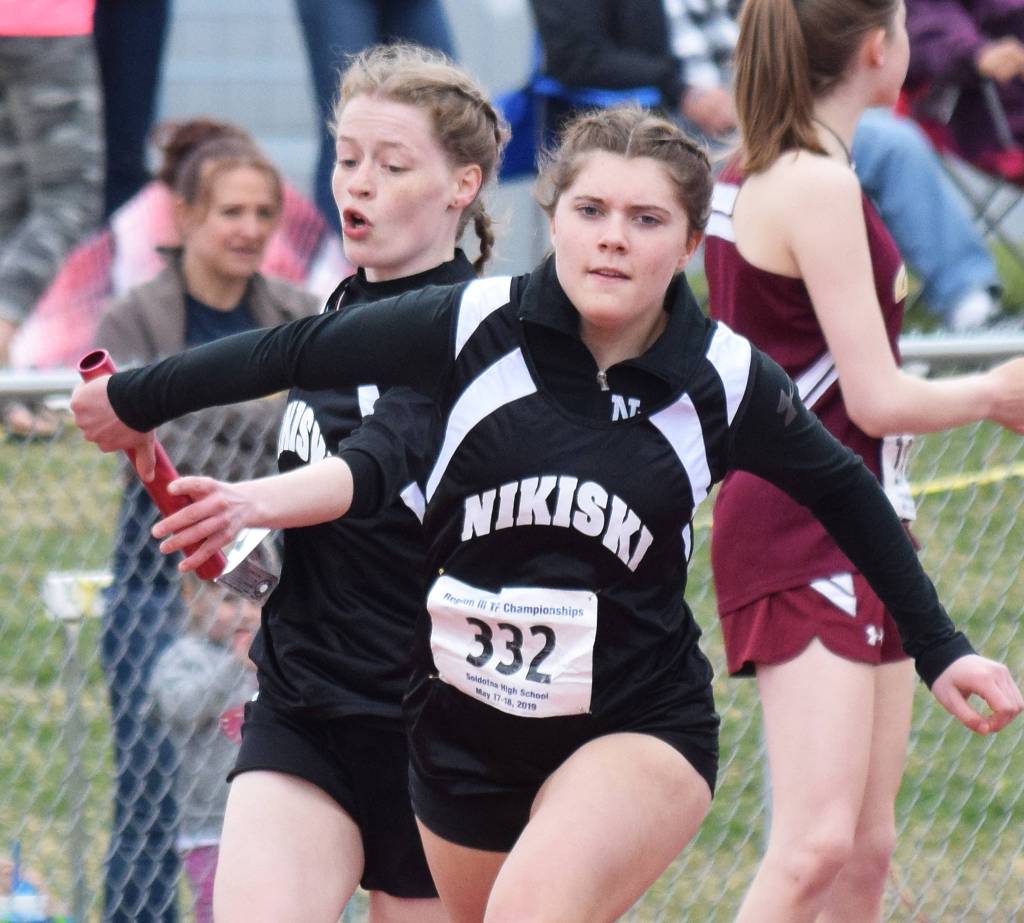 Nikiskis Sidney Epperheimer passes the baton off to teammate Shylea Freeman in the Class 3A girls 800-meter relay Saturday at the Region III Track and Field championships in Soldotna. (Photo by Joey Klecka/Peninsula Clarion)