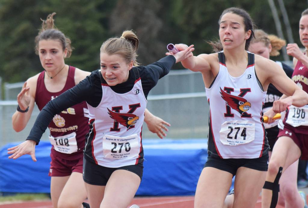 Kenai Centrals Chelsea Plagge (right) hands off the baton to teammate Hayley Maw in the Class 3A girls 400-meter relay Saturday, May 18, 2019, at the Region III Track and Field Championships in Soldotna, Alaska. (Photo by Joey Klecka/Peninsula Clarion)