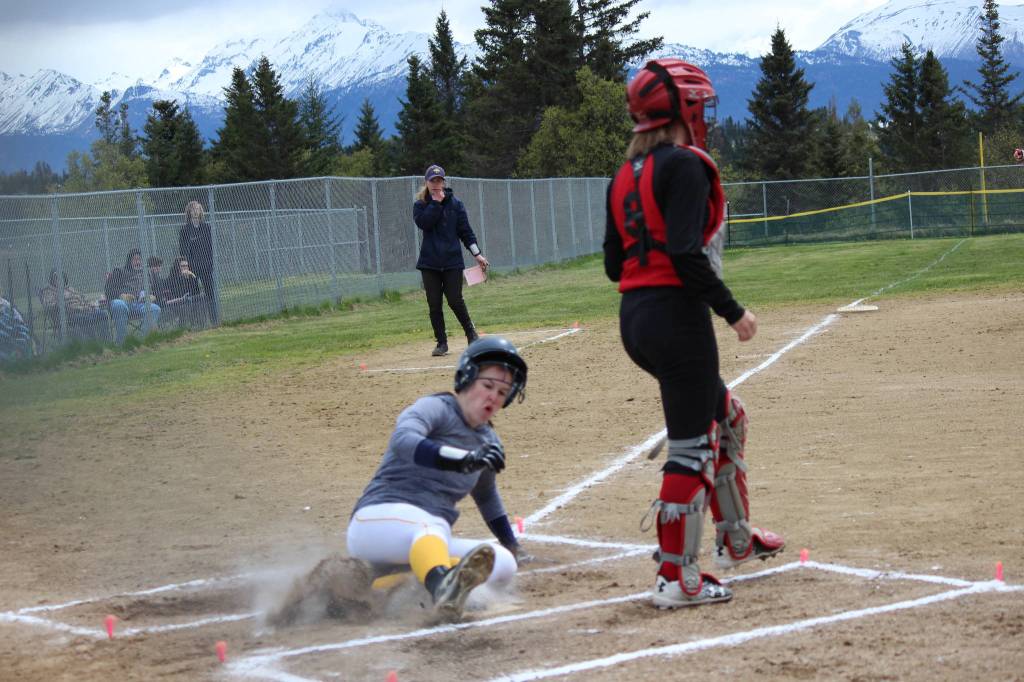 Mariner Grace Godfrey slides across home plate during Saturdays game against the Kenai Central Kardinals. Godfrey scored three runs during the game, one in the first inning and two in the second. (Photo by McKibben Jackinsky)