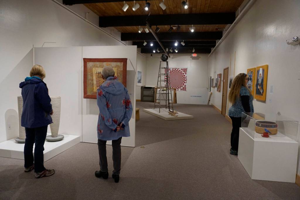 Visitors view the All Alaska Biennial exhibit at the Pratt Museum for its grand reopening on May 25, 2019, in Homer, Alaska. The Special Exhibits Gallery staircase at back was redone to expand the gallery space and add a three-stop lift. (Photo by Michael Armstrong/Homer News)