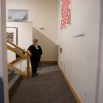 Savanna Bradley, Pratt Museum collections manager, stands in the newly remodeled mezzanine off the special exhibits gallery on May 28, 2019, in Homer, Alaska. The floor was raised to be on the same level as the Marine Gallery, with a new door connecting them. A three-stop left behind Bradley offers handicapped access to the main floor, the Marine Gallery, and the lower level. (Photo by MIchael Armstrong/Homer News)