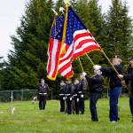 Member of the Veterans of Foreign Wars, Anchor Point, stand at attention during the playing of Taps by a bugler with the U.S. Pacific Fleet Band at Memorial Day ceremonies on Monday, May 27, 2019, at Hickerson Memorial Cemetery in Homer, Alaska. About 75 people braved a blustery wind to attend the ceremonies. (Photo by Michael Armstrong/Homer News)