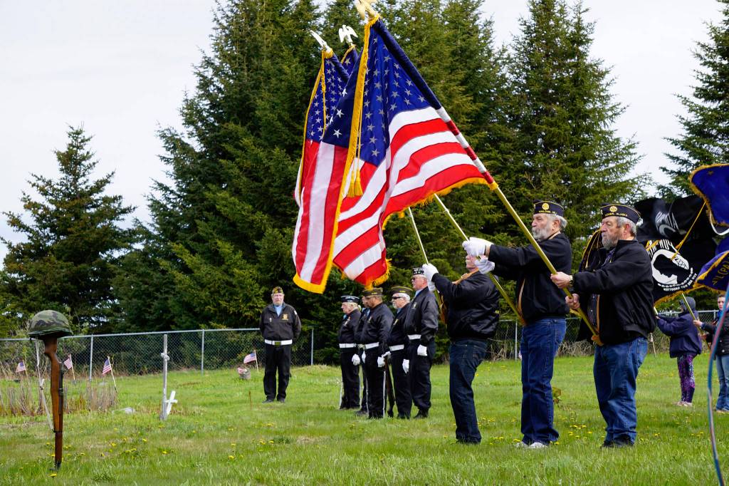 Member of the Veterans of Foreign Wars, Anchor Point, stand at attention during the playing of Taps by a bugler with the U.S. Pacific Fleet Band at Memorial Day ceremonies on Monday, May 27, 2019, at Hickerson Memorial Cemetery in Homer, Alaska. About 75 people braved a blustery wind to attend the ceremonies. (Photo by Michael Armstrong/Homer News)