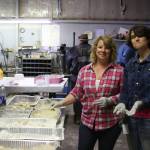 Brandi Blauvelt, left, and Ruth Mitchell, right, prepare freshly caught halibut for the fifth annual Customer Appreciation Day and 50th anniversary celebration on Saturday, May 25 at Thurmonds Far West Auto in Anchor Point, Alaska. (Photo by Delcenia Cosman)