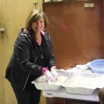 Elaine Griner helps prepare freshly caught halibut for the fifth annual Customer Appreciation Day and 50th anniversary celebration on Saturday, May 25 at Thurmonds Far West Auto in Anchor Point, Alaska. (Photo by Delcenia Cosman)