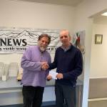 Homer News Editor Michael Armstrong, left, is presented with an award from Publisher Jeff Hayden on May 10, 2019 at the Homer News office in Homer, Alaska. (Photo by Malia Anderson)