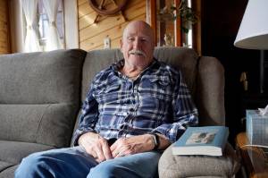 Sandy Mazen poses with a copy of his memoir, Kiyonuk, at his Homer, Alaska, home on April 22, 2019. (Photo by Michael Armstrong)