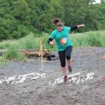 Danielle Harrison, 251, navigates through a sandy hopscotch course, one of several challenges added to the 5K fun run, the Clam Scramble held Saturday, June 15, 2019 in Ninilchik, Alaska. (Photo by McKibben Jackinsky)