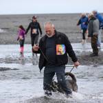 Tom Farrell and his canine running partner, Kiladai, cross the mouth of Deep Creek. Farrell, 80, was the oldest participate in 2019 Clam Scramble, a 5K fun run held on Saturday, June 15, 2019 in Ninilchik, Alaska. (Photo by McKibben Jackinsky)