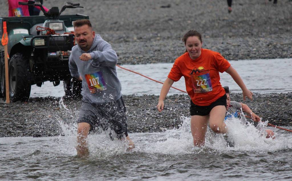 Jon Marsh, 107, and Mckenzie Lindeman, 222, dont let a little cold water slow them down in the Clam Scramble held Saturday June 15, 2019 on Ninilchik beach, Alaska. (Photo by McKibben Jackinsky)