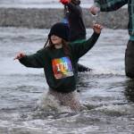 Unbothered by a drooping sweatshirt hood, Emma Berger, 179, relies on her feet to find a way across the gravel bottom of Deep Creek during the Clam Scramble held June 15, 2019 in Ninilchik, Alaska. (Photo by McKibben Jackinsky)