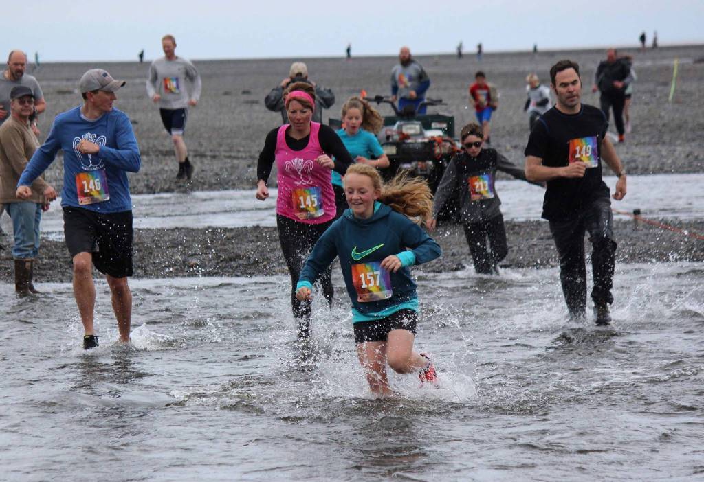 Undaunted by the rugged course, athletes young and old participate in Saturdays 2019 Clam Scramble, a 5K fun run Saturday, June 15, 2019 in Ninilchik, Alaska. Kylee Verkulien, 157, leads this group of runners through the cold and fast-moving water at the mouth of Deep Creek. (Photo by McKibben Jackinsky)
