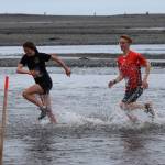 Leah Fallon, left, and Tyler Hippchen, right, dash through the chilly water of Deep Creek in the Clam Scramble, held Saturday, June 15, 2019, in Ninilchik, Alaska. Fallon finished ninth overall and was the first female finisher with a time of 29 minutes, 42 seconds. Hippchen finished seventh overall in 29:36.(Photo by McKibben Jackinsky)