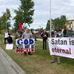 Demonstrators hold signs outside the Kenai Peninsula Borough building in protest of an invocation by a member of the Satanic Temple on Tuesday, June 18, 2019 in Soldotna, Alaska. The invocation was the first given by the Satanic Temple since the borough changed its invocation policy following an Alaska Superior Court decision finding the policy unconstitutional and in violation of the states constitutions establishment clause. (Photo courtesy Aud Walaszek)