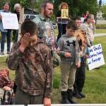 Demonstrators hold signs outside the Kenai Peninsula Borough building in protest of an invocation by a member of the Satanic Temple on Tuesday, June 18, 2019 in Soldotna, Alaska. The invocation was the first given by the Satanic Temple since the borough changed its invocation policy following an Alaska Superior Court decision finding the policy unconstitutional and in violation of the states constitutions establishment clause. (Photo courtesy Aud Walaszek)