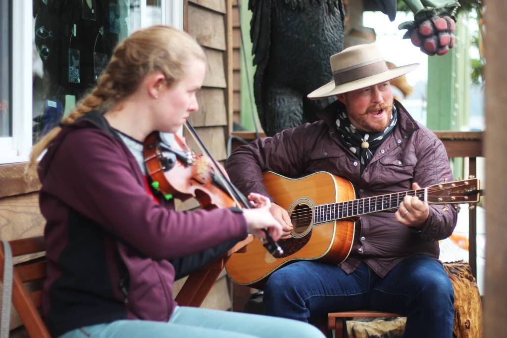 Noah Procter (right) and Kelly Barber perform outside the Seldovia Harbor Inn on Friday, June 21, 2019 as part of a round of street performances during the Seldovia Summer Solstice Music Festival in Seldovia, Alaska. (Photo by Megan Pacer/Homer News)