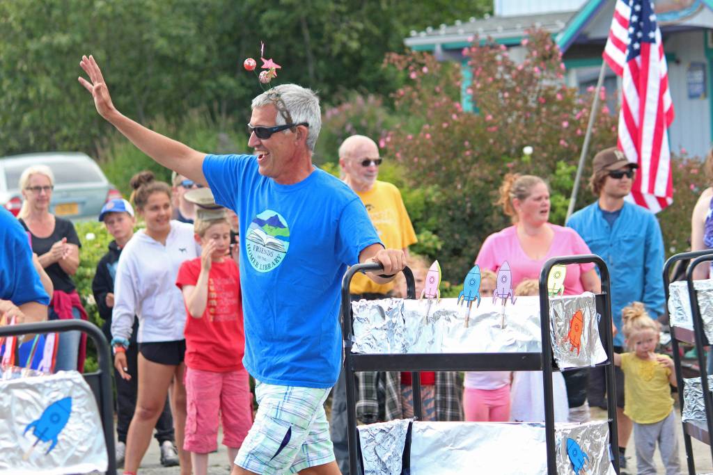 Andy Haas marches in the July Fourth parade with the Friends of the Homer Library on Thursday, July 4, 2019 on Pioneer Avenue in Homer, Alaska. The Friends of the Homer Library performed a synchronized dance with their book carts to the main theme from Star Wars. (Photo by Megan Pacer/Homer News)