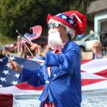 A member of the Homer Senior Citizens Center float marches in this years July Fourth parade on Thursday, July 4, 2019 on Pioneer Avenue in Homer, Alaska. (Photo by Megan Pacer/Homer News)