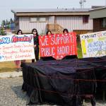 People draped in black hold signs on July 9, 2019, by Sean Derrys public art sculpture in Homer, Alaska, as part of a statewide art intervention to protest Gov. Mike Dunleavys veto of a $2.8 million state appropriation to the Alaska State Council on the Arts. They also supported a general override of Dunleavys vetoes that will affect funding for the University of Alaska, public radio and other programs. Derrys sculpture was commissioned as a 1% for art project associated with the remodeling of Pioneer Hall at the Kachemak Bay Campus, Kenai Peninsula College, University of Alaska. The protest was not sanctioned by the college. (Photo by Michael Armstrong/Homer News)