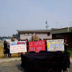 Arts supporters draped in black holds sings on July 9, 2019, by Sean Derrys public art sculpture in Homer, Alaska, as part of a statewide art intervention to protest Gov. Mike Dunleavys veto of a $2.8 million state appropriation to the Alaska State Council on the Arts. They also supported a general override of Dunleavys vetoes that will affect funding for the University of Alaska, public radio and other programs. Derrys sculpture was commissioned as a 1% for art project associated with the remodeling of Pioneer Hall at the Kachemak Bay Campus, Kenai Peninsula College, University of Alaska. The protest was not sanctioned by the college. (Photo by Michael Armstrong/Homer News)