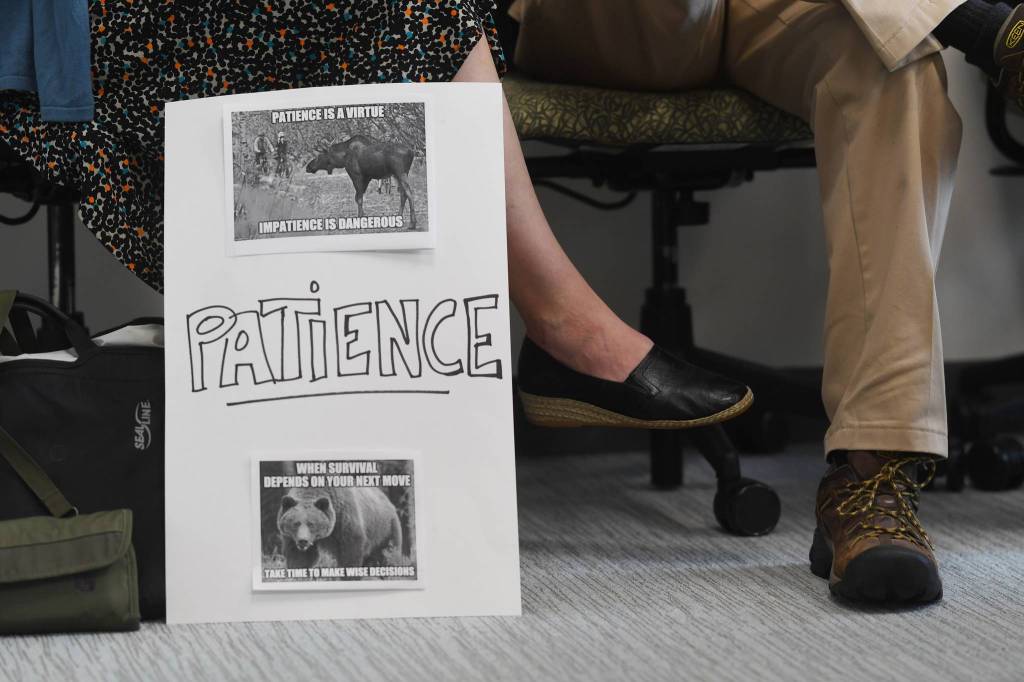 University of Alaska Southeast staffer displays a poster during an online meeting being held at UA campuses around the state on Gov. Mike Dunleavys budget cuts on Monday, July 15, 2019. (Michael Penn | Juneau Empire)