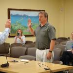Homer Mayor Ken Castner, left, swears in new Homer Volunteer Fire Department Chief Mark Kirko, center, as former Acting Chief Robert Purcell, right, watches at the Homer City Council regular meeting held July 22, 2019, in the Cowles Council Chambers, Homer City Hall, in Homer, Alaska. Castner also read a letter of appreciation to Purcell, a former HVFD fire chief, thanking him for coming out of retirement to serve as acting chief. (Photo by Michael Armstrong/Homer News)