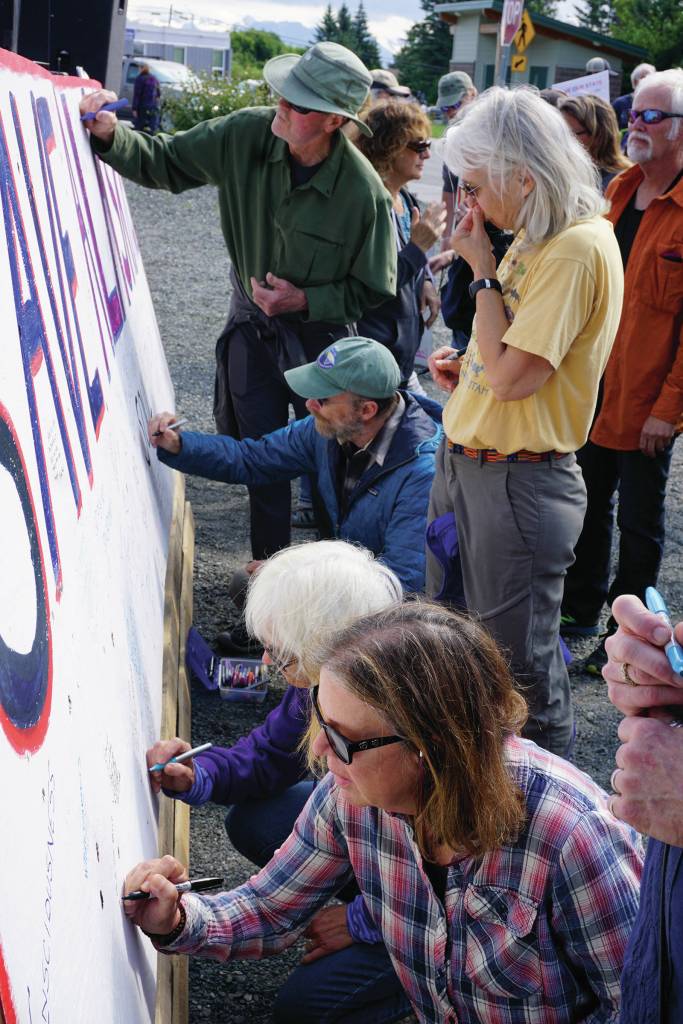 People respond to a prompt on a sign that reads Save Alaskas ____ at a rally Sunday, July 28, 2019, against Gov. Mike Dunleavys budget cuts at the Legislative Information Office, Homer, Alaska. (Photo by Michael Armstrong/Homer News).