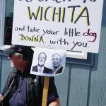 Darrell Oliver holds a sign with photos of the Koch brothers at a rally Sunday, July 28, 2019, against Gov. Mike Dunleavys budget cuts at the Legislative Information Office, Homer, Alaska. The Donna reference is to Office of Management and Budget Director Donna Arduin. (Photo by Michael Armstrong/Homer News).
