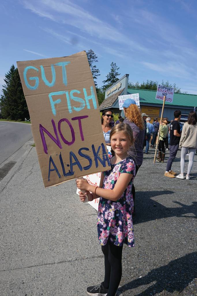 Morgan Harness holds a sign at a rally Sunday, July 28, 2019, against Gov. Mike Dunleavys budget cuts at the Legislative Information Office, Homer, Alaska. (Photo by Michael Armstrong/Homer News).